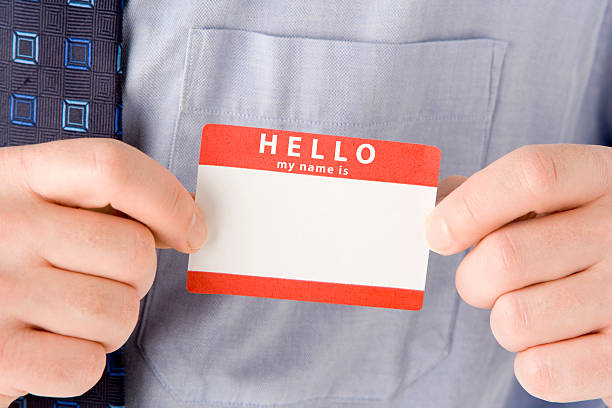 A Close Up Of Businessman Attaching Name Tag to shirt